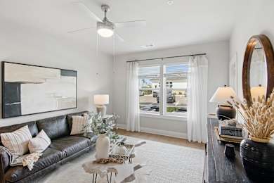 A living room with a black couch, a coffee table, and a large mirror.