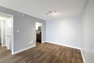 A room with wooden flooring and white walls.