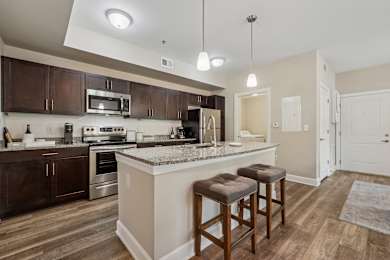 A kitchen with a bar area and two stools.