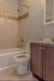 A white toilet sits next to a bathtub in a bathroom.