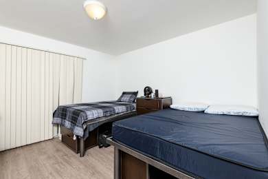 a bedroom with two beds and a large window