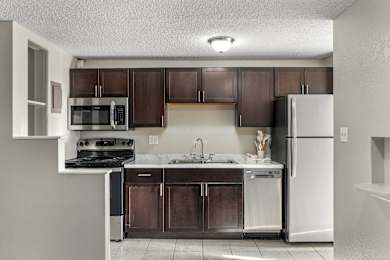 A kitchen with brown cabinets and a white refrigerator.