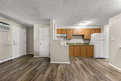 A kitchen with wooden floors and white appliances.