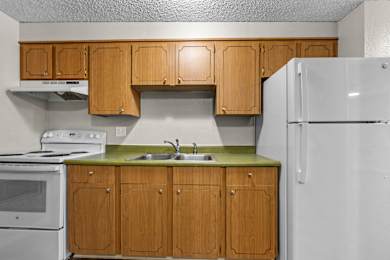 A kitchen with wooden cabinets and a white refrigerator.