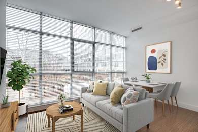 A living room with a grey couch, a coffee table, and a painting on the wall.