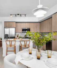 A modern kitchen with a dining table set for two.