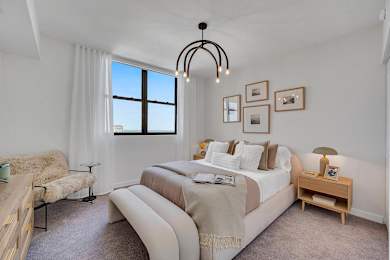 A bedroom with a large bed and a window.