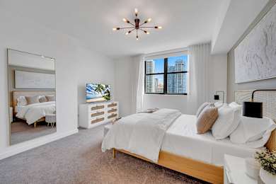A bedroom with a large bed and a view of the city.