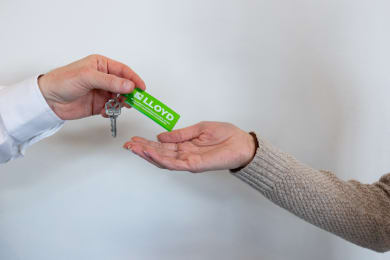 a man holding a condom in his hand and another person holding a key