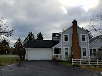 A house with a white fence and a brick chimney.