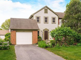 A house with a white garage door and a brown door.