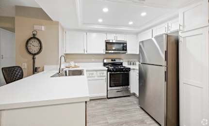A modern kitchen with a white countertop and stainless steel appliances. at The Oaks Apartments, California, 91786