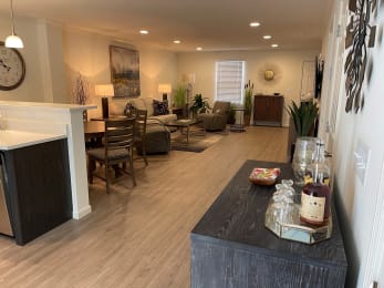 a kitchen and living room with a large clock on the wall