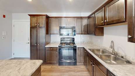 A kitchen with wooden cabinets and a stainless steel sink.