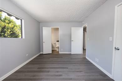 A room with white walls and a window on the left side.