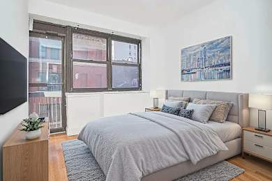 A bedroom with a large bed and a painting on the wall.
