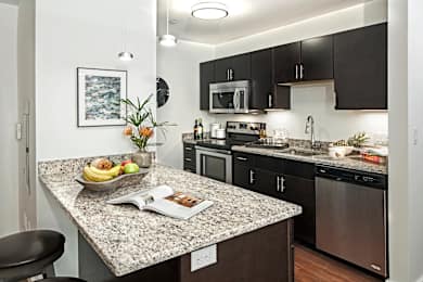 A kitchen with granite countertops and stainless steel appliances.