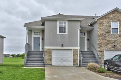 Floor Plan  a gray house with a car parked in a driveway