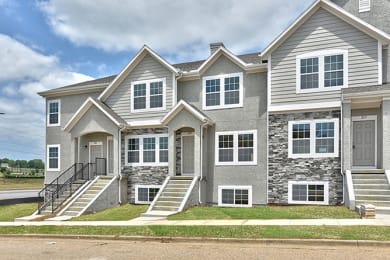 Floor Plan  a large house with stone and gray siding