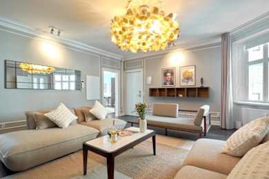 A living room with a beige sofa, a coffee table, and a chandelier.