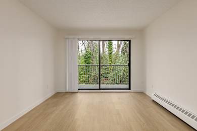 A room with a sliding glass door leading to a garden.