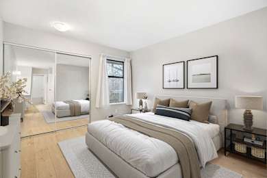 A bedroom with a large bed and a mirror on the wall.