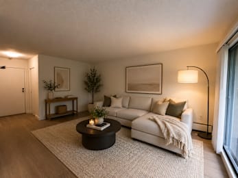 A modern living room with a white couch and a coffee table.