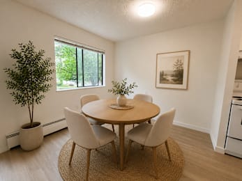 A dining room with a round table and chairs.