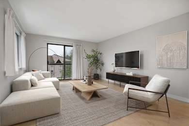 A living room with a white sofa, a wooden coffee table, and a television.