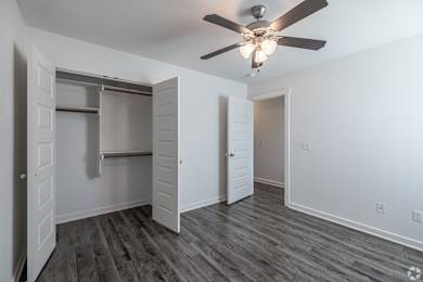 A room with a ceiling fan and a closet with a sliding door.