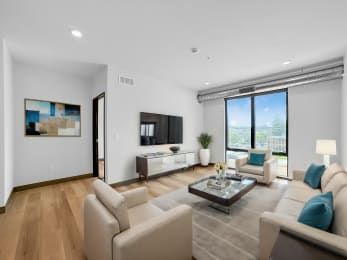 a living room with white furniture and a large window