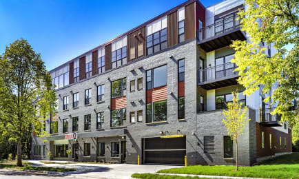 a brick building with a parking lot and trees