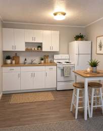Floor Plan  A kitchen with white appliances and wooden floors.