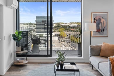 a living room with a balcony and a view of the city