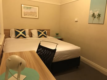 a small hotel room with a bed and a table