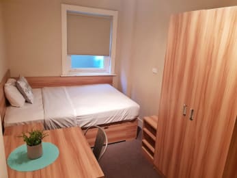 a small bedroom with a bed and a desk