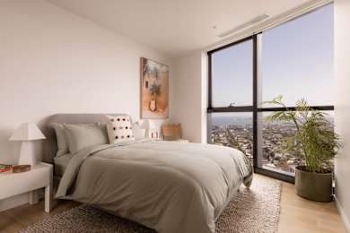 A bedroom with a large bed and a view of the city.