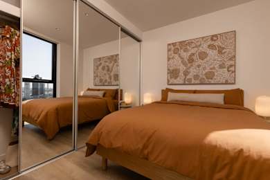 A bedroom with two beds and a large painting on the wall.