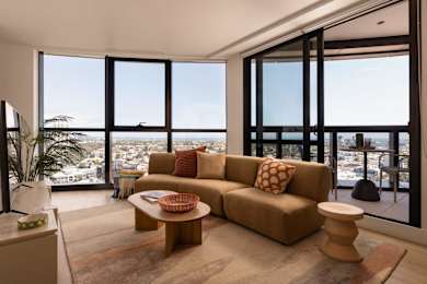 A living room with a couch, a table, and a view of the city.