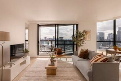 A modern living room with a grey couch and a flat screen TV.