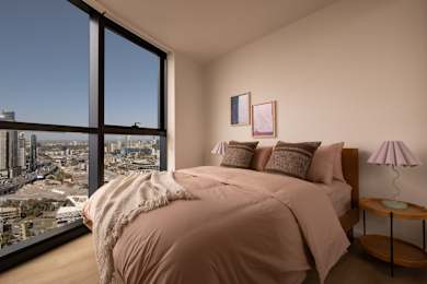 A bedroom with a large bed and a view of the city.