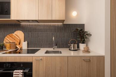 A modern kitchen with wooden cabinets and a dark countertop.