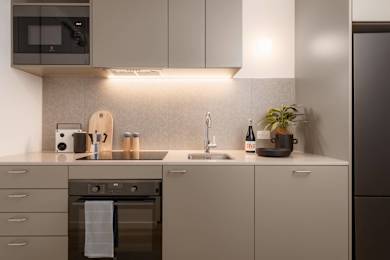 A modern kitchen with a stainless steel oven and a microwave above it.