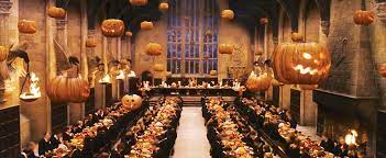 A large hall filled with people sitting at long tables.