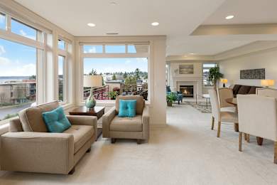 A living room with a fireplace and a view of the street outside.