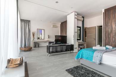 A modern bedroom with a large bed and a television.