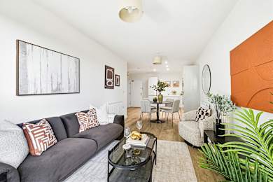 Floor Plan  A living room with a grey couch and a coffee table.