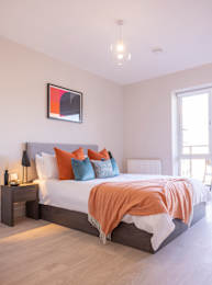 Floor Plan  A bedroom with a bed, nightstand, and a painting on the wall.