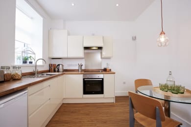 Floor Plan  a kitchen with white cabinets and a table and chairs