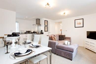 A modern dining room with a white table set for two.